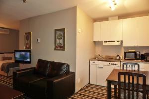 a living room with a couch and a kitchen at Complexe Le 60 in Piedmont