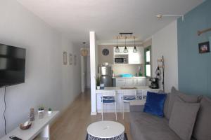 a living room with a couch and a kitchen at OceanEye Apartment with heated pool in Mogán