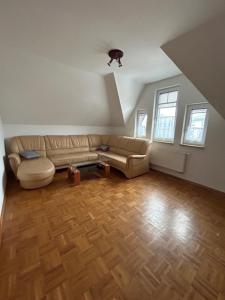 a living room with a couch and wooden floors at Bennis Rodelhaus in Oberhof