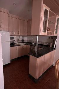 a kitchen with white cabinets and a black counter top at Casa Casidro in Chulilla
