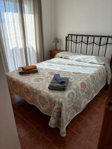a bedroom with a bed with a blanket and towels on it at Casa Casidro in Chulilla
