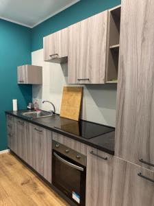 a kitchen with wooden cabinets and a black counter top at Tiber Domus Fiumicino - Apt 3 in Fiumicino