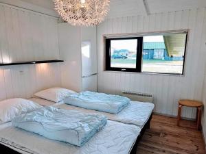 2 Einzelbetten in einem Zimmer mit Kronleuchter in der Unterkunft Holiday Home Auvo - 600m from the sea by Interhome in Hjørring + 10 Fotos