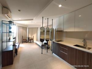 a kitchen with a couch and a table in a room at Rent Homecation at Tambuli Seaside Living in Maribago