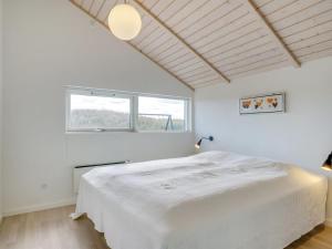 a white bedroom with a large bed and a window at Holiday Home Aria - 1-2km from the sea by Interhome in Hirtshals