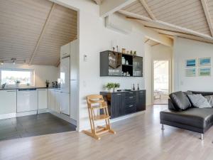 a living room with a couch and a kitchen at Holiday Home Aria - 1-2km from the sea by Interhome in Hirtshals +20 photos