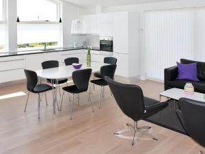 a kitchen and dining room with a table and chairs at Holiday Home Ugot - 750m from the sea by Interhome in Frederikshavn
