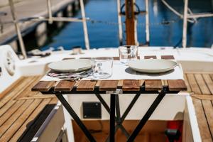 a table with plates and glasses on a boat at Romantic Sailboat Retreat Marina de Alcantara Downtown Lisbon in Lisbon