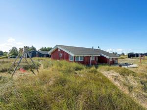 a red house in the middle of a field at Holiday Home Bertie - 700m from the sea by Interhome in Hirtshals