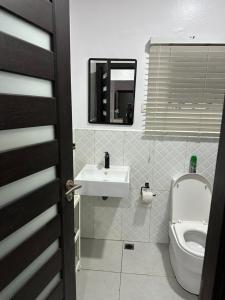 a bathroom with a sink and a toilet and a mirror at Royal tamah concept in Ikate