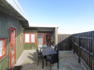 a patio with a table and chairs and a fence at Holiday Home Nea - 234m from the sea by Interhome in Hirtshals