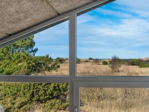 a window view of a field from a house at Holiday Home Riika - 425m from the sea by Interhome in Hirtshals