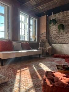a living room with a couch and some windows at RetreatHouse in Lith
