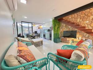 a living room with chairs and a stone wall at Bella Arte 2 Rooftop in Aquiraz