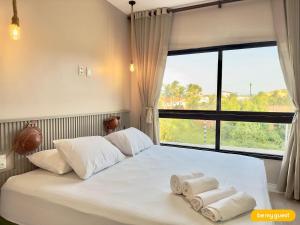 a bedroom with a white bed with towels on it at Bella Arte 2 Rooftop in Aquiraz +41 photos