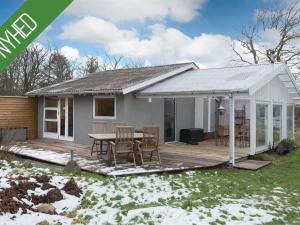 a small house with a deck and a table at Holiday Home Gonda - 500m from the sea by Interhome in Frederikshavn