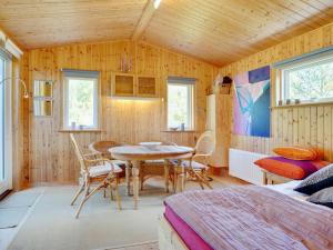 a room with a table and chairs and a bed at Holiday Home Ascen - 300m from the sea by Interhome in Læsø