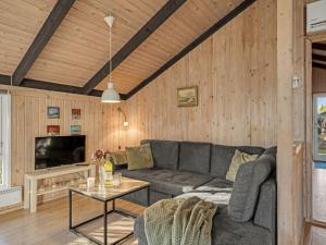 a living room with a couch and a tv at Holiday Home Eliana - 350m from the sea by Interhome in Strandby