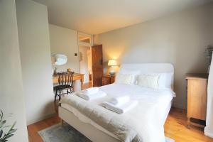 une chambre avec un lit blanc avec deux serviettes dessus dans l'établissement 28 Millgate Cosy Dog Friendly Cottage in Aylsham, à Aylsham