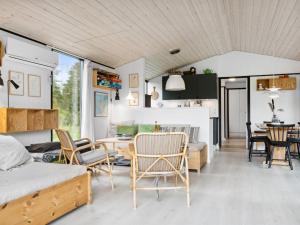 a bedroom and living room with a bed and chairs at Holiday Home Shayene - 2-5km from the sea by Interhome in Læsø