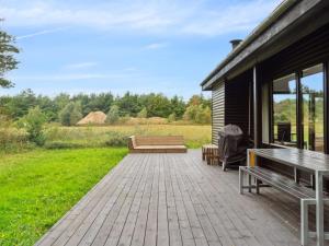 a patio with two benches and a building at Holiday Home Shayene - 2-5km from the sea by Interhome in Læsø