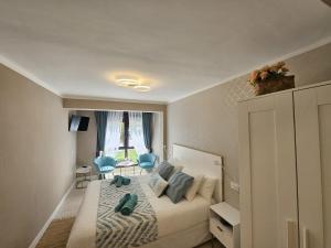 1 dormitorio con 1 cama con sillas azules y ventana en Central Park, en Bermeo