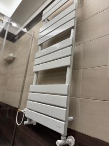 een wit handdoekenrek aan een muur in een badkamer bij Kairos Relais in Napels