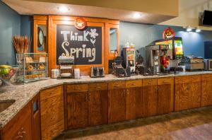 a restaurant counter with a think spring sign on the wall at AmericInn by Wyndham Spencer in Spencer