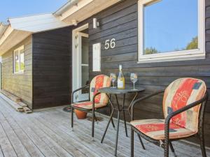a patio with two chairs and a table with wine glasses at Holiday Home Hampus - 500m from the sea by Interhome in Strandby