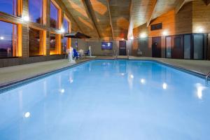 a large swimming pool in a building at AmericInn by Wyndham Spencer in Spencer