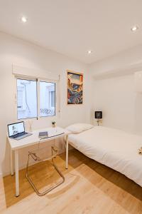 バレンシアにあるCabañal Beach House - 10 min to ocean , FastWifi , SmartTV, ACのベッドルーム1室(ベッド1台、ノートパソコン付きのデスク付)