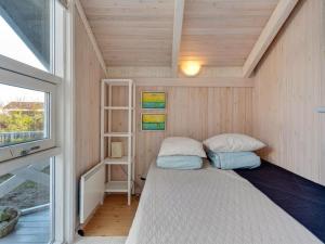 a small bed in a small room with a window at Holiday Home Bille - 200m from the sea by Interhome in Læsø