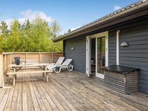 a deck with a picnic table and chairs on a house at Holiday Home Ellie - 300m from the sea by Interhome in Læsø
