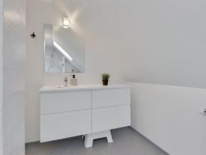 a white bathroom with a sink and a mirror at Holiday Home Juhana - 150m from the sea by Interhome in Skagen +21 photos