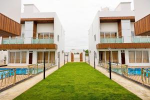 a row of buildings with a green lawn in the middle at ASJ Holiday Villa in Pondicherry