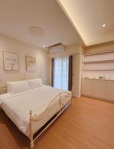 a bedroom with a large white bed in a room at Station B&B in Tainan