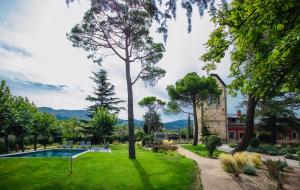 a garden with a swimming pool and trees at El Torreón de Cepones in Segovia