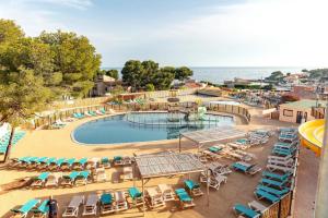 een zwembad met ligstoelen en de oceaan bij Vertacoflav in Carry-le-Rouet