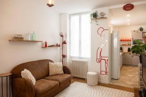 a living room with a couch and a refrigerator at Bel Appartement à Orléans - Le Nid de L'ours - Unique refuge in Orléans