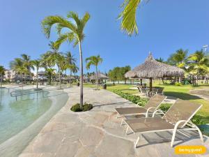ein Resort mit Stühlen, einem Pool und Palmen in der Unterkunft Condomínio Aquaville Resort in Mangabeira