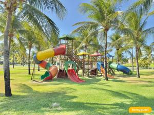 einen Spielplatz mit Rutsche in einem Park mit Palmen in der Unterkunft Condomínio Aquaville Resort in Mangabeira