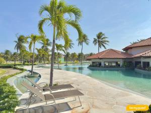 ein Resort-Swimmingpool mit einer Bank und Palmen in der Unterkunft Condomínio Aquaville Resort in Mangabeira