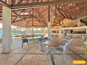 einen Essbereich mit Tischen und Stühlen in einem Gebäude in der Unterkunft Condomínio Aquaville Resort in Mangabeira
