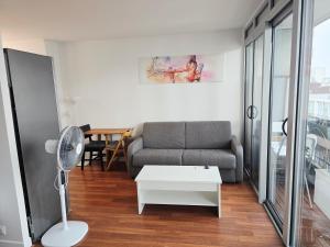 una sala de estar con un sofá y una mesa en Rob’s Place - Paris Convention Center, en Vanves
