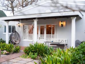 a white house with a porch and a patio at Connie’s Cottages in Montagu