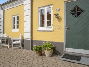 a yellow house with two potted plants in front of it at Holiday Home Stephie - 1-1km from the sea by Interhome in Skagen