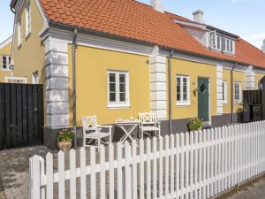a yellow house with a white picket fence at Holiday Home Stephie - 1-1km from the sea by Interhome in Skagen