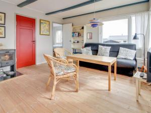 a living room with a table and a couch at Holiday Home Sohvi - 450m from the sea by Interhome in Lakolk