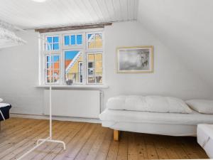 a white bedroom with a bed and a window at Holiday Home Ortrud - 200m from the sea by Interhome in Skagen