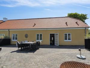 a yellow house with a table and chairs in front of it at Apartment Viivi - 900m from the sea by Interhome in Skagen